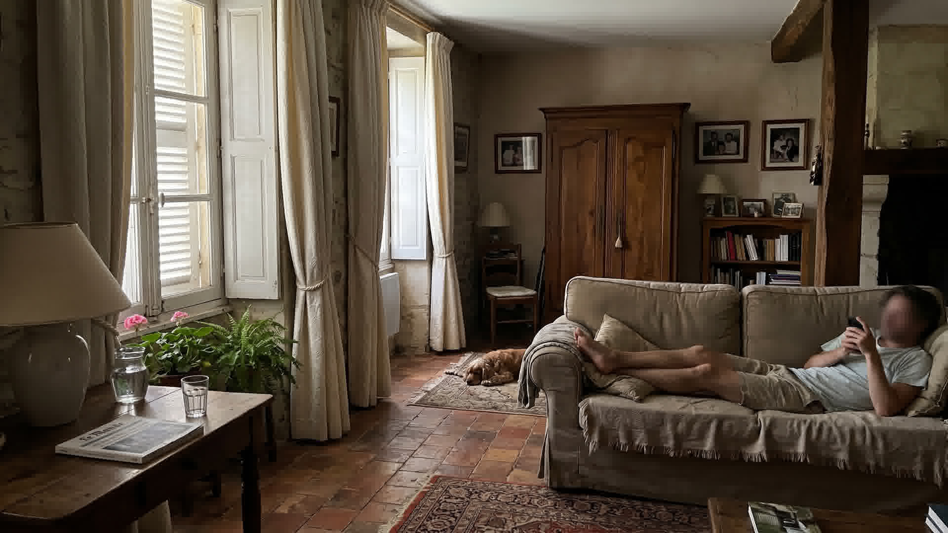 Intérieur d'une maison française avec volets fermés et rideaux tirés pendant une journée chaude d'été
