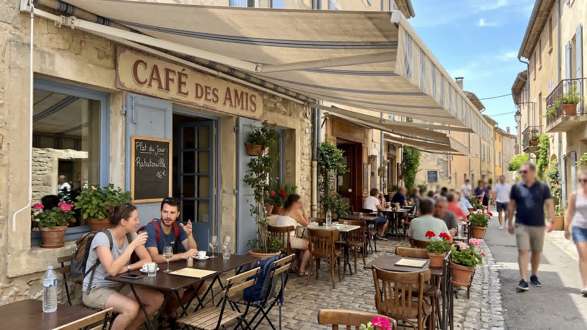 Store banne rétractable déployé au-dessus d'une terrasse française avec meubles de jardin à l'ombre