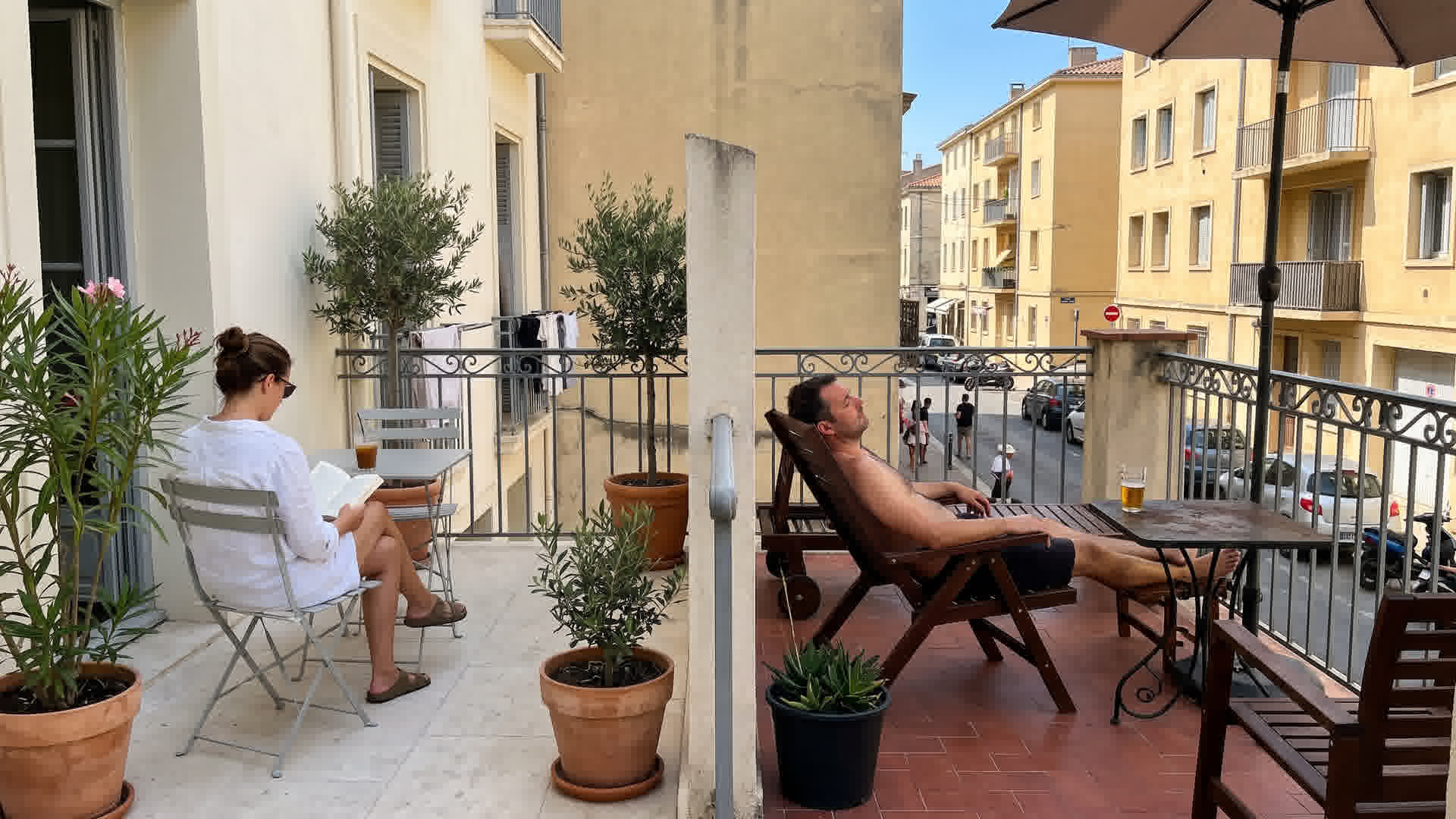 Deux terrasses côte à côte dans une rue française comparant couleur claire fraîche et couleur foncée chaude, toutes deux orientées sud
